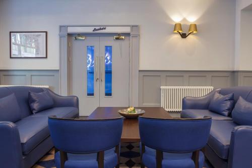 a living room with blue chairs and a table at Temple Bar Hotel Dublin by The Unlimited Collection in Dublin