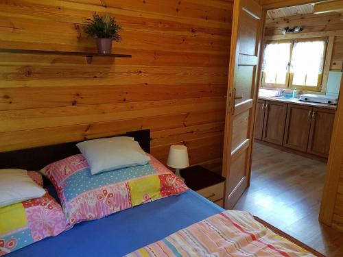 a bedroom with a bed and a wooden wall at Zacisze Bałtyku in Rusinowo