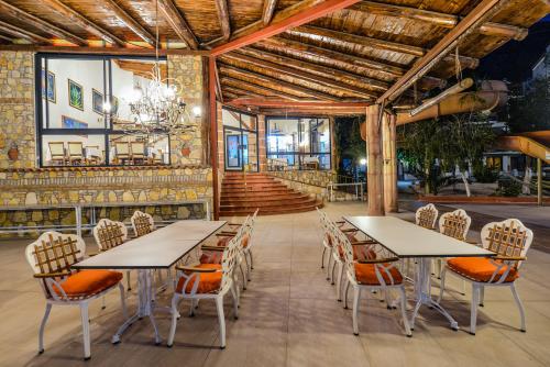 a dining room with two tables and chairs at Seyir Village Hotel in Oludeniz