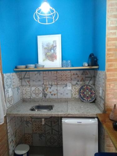 a bathroom with a sink and a blue wall at Sítio do Sauá in Cunha
