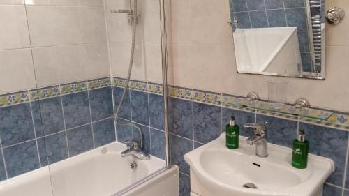 a bathroom with a sink and a toilet and a mirror at Central Home with Parking near Waterloo & St Thomas & Big Ben & Parliament in London