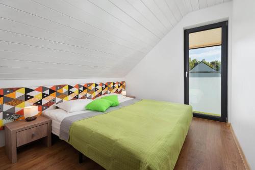 sypialnia z łóżkiem i dużym oknem w obiekcie Domki Morski Raj w Dębkach