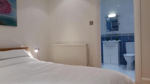 a bedroom with a bed and a bathroom with a toilet at Central Home with Parking near Waterloo & St Thomas & Big Ben & Parliament in London