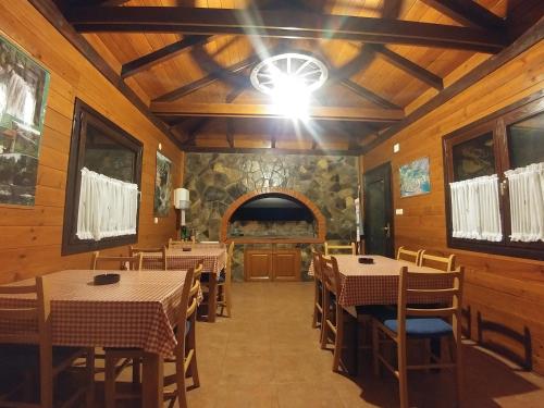 una sala da pranzo con tavoli, sedie e soffitto di House Pavlic a Grabovac