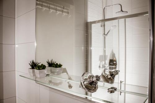a bathroom with a glass shelf and a mirror at Apartman Dujmović in Split