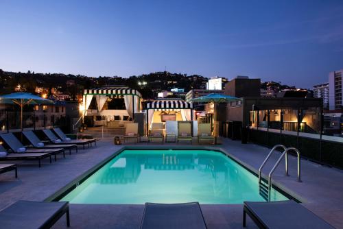 a swimming pool with a pool table and chairs at Chamberlain West Hollywood in Los Angeles
