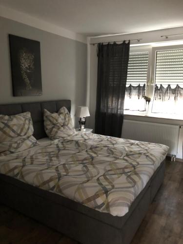 een slaapkamer met een groot bed en 2 ramen bij Ferienwohnung Anke - Apartment 5a in Heinsberg