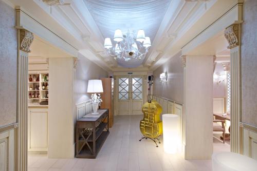 un couloir avec un lustre, une table et une guitare jaune dans l'établissement Grand Hotel Classic, à Armavir