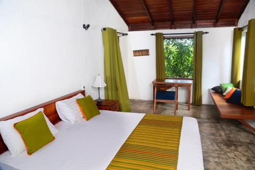 1 dormitorio con cama, sofá y ventana en Villa by the Lake Bolgoda, Moratuwa-Colombo, en Moratuwa