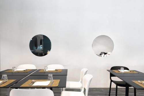 a dining room with black tables and white chairs at Garda Hotel in Montichiari