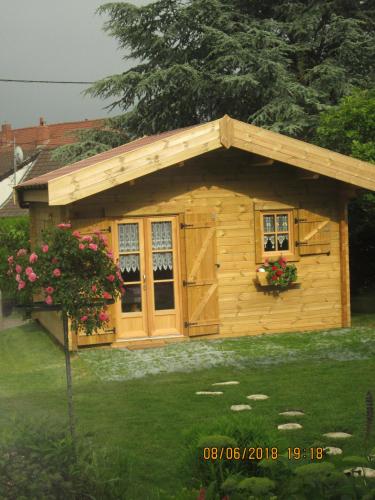 a small wooden shed with a roof and windows at studios les Hortensias in Lillers