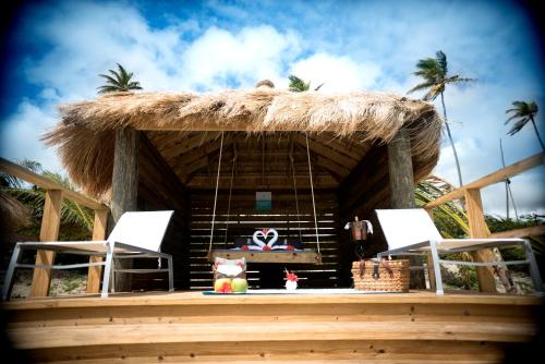 une cabane avec 2 chaises et un toit de chaume dans l'établissement Serenity at Coconut Bay - All Inclusive, à Vieux-Fort