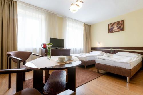 una camera d'albergo con due letti e un tavolo di Halny Pensjonat a Zakopane