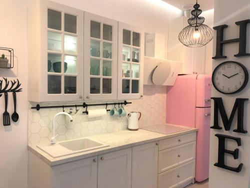 cocina con armarios blancos y nevera rosa en Apartament BellaPola 2, en Nysa