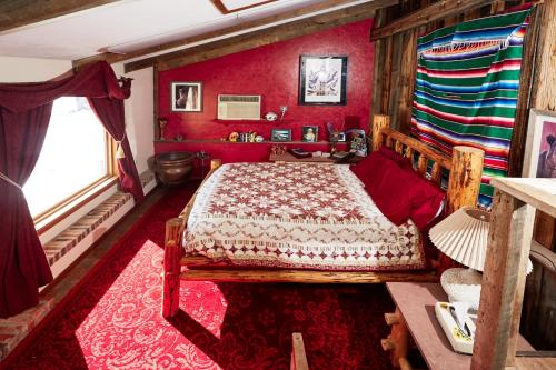 a bedroom with a bed in a room with red walls at Devils Tower Lodge in Devils Tower