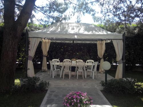 a table and chairs under a white canopy at B&B LE MAGNOLIE in Gallarate