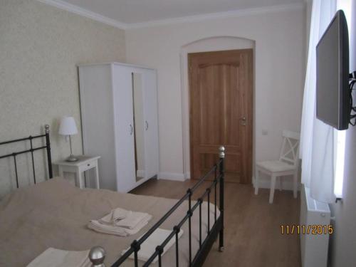 a room with a bed and a table and a door at Villa Shafaly in Mariánské Lázně