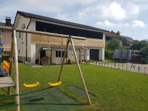a swing in a yard next to a house at Apartment GREEN&URBAN in Celje