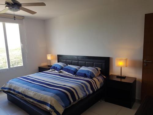 Un dormitorio con una cama grande con almohadas azules. en Cancun Amara, en Cancún