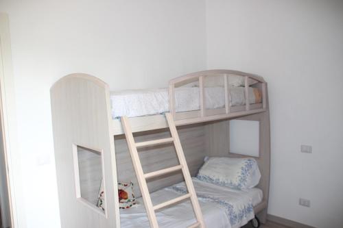 a white bunk bed with a ladder in a room at Carolina Apartment in Rapolano Terme