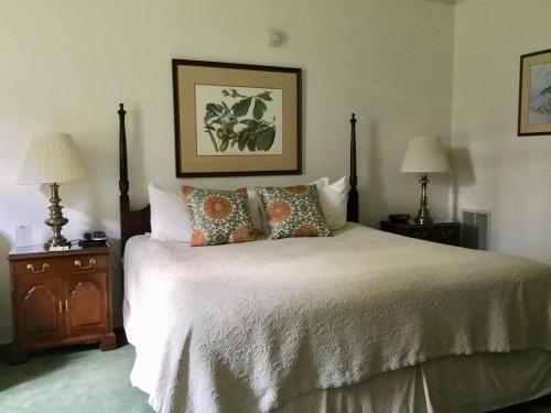 a bedroom with a bed with pillows and two lamps at The Inn at Houndslake in Aiken