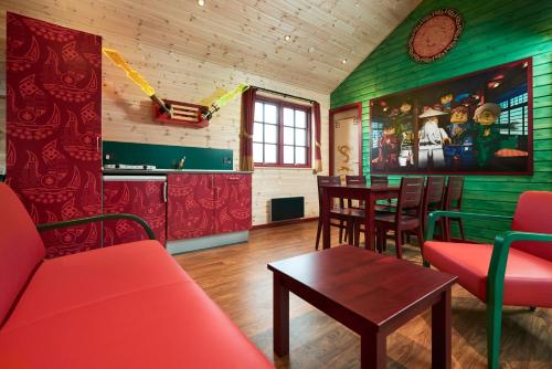 sala de estar con sofá rojo y mesa en LEGOLAND NINJAGO Cabins, en Billund