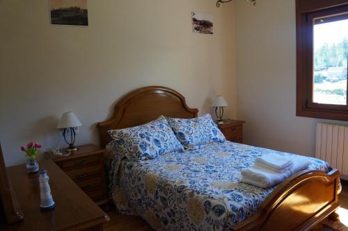 a bedroom with a bed and two night stands and a window at A Veiga Grande in Pontevedra