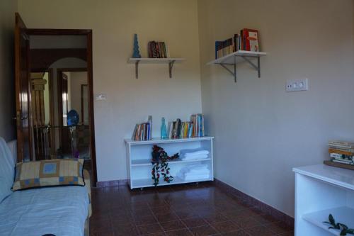 a bedroom with a bed and a shelf with books at A Veiga Grande in Pontevedra