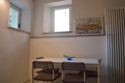uma mesa de jantar com 2 cadeiras e uma janela em Il Posto dell’Origano em La Spezia