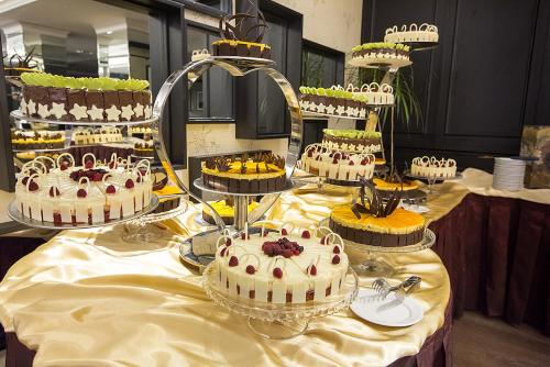 a table with many cakes on top at Ramada Iasi City Center in Iaşi
