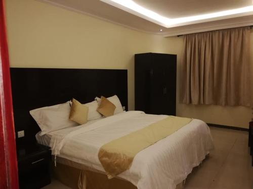 a bedroom with a large bed with white sheets and pillows at Saad Palace Residential Units - Al Rabwa 2 in Abha