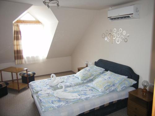 Un dormitorio con una cama con cisnes. en Pálma Apartmanház Harkány, en Harkány