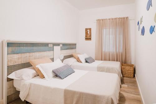 ポリス・デ・アボナにあるDesconecta a Orillas del Marの白い壁の客室内のベッド2台