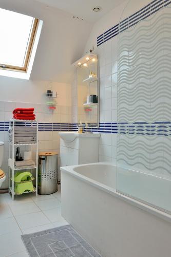 une salle de bain blanche avec une baignoire et une douche dans l'établissement Les Gîtes de la Vallée de l'Elle, à Villac