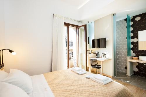a bedroom with a bed with two towels on it at Ark 68 City Rooms in Rethymno Town