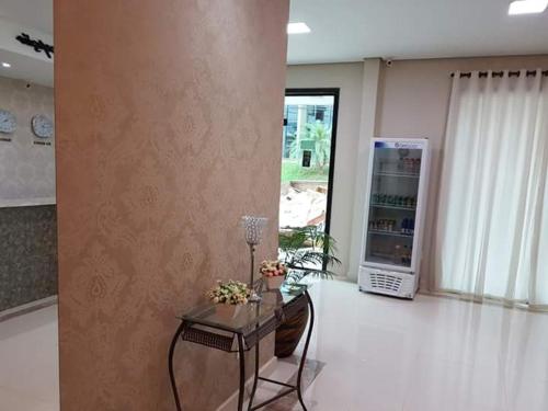 ein Wohnzimmer mit einem Tisch und einem Kühlschrank in der Unterkunft Hotel Loureiro in Rio Branco