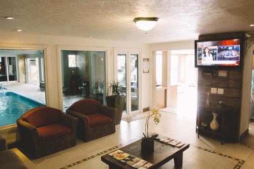 a living room with a tv and a swimming pool at Sky Centro Hotel & SPA in Gramado