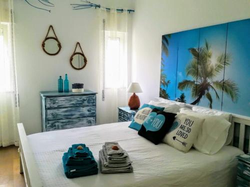 une chambre avec un lit blanc avec des serviettes dessus dans l'établissement Gui Beach House, à Armação de Pêra