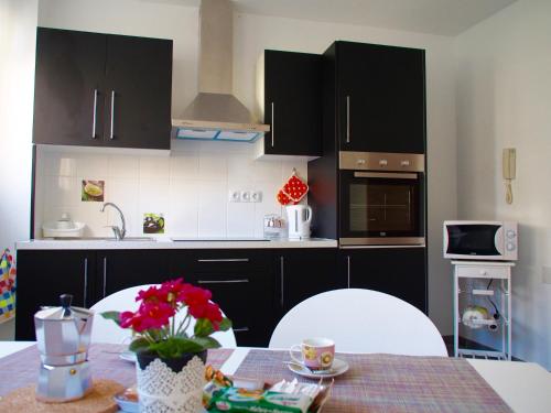 una cocina con armarios negros y una mesa con flores en Apartamento Primavera, en Las Palmas de Gran Canaria