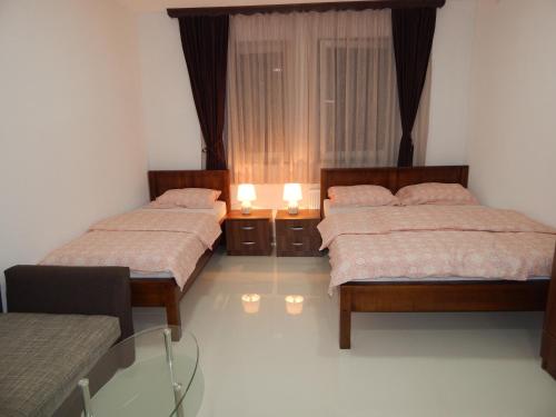 1 dormitorio con 2 camas y mesa de cristal en Apartments S&S, en Konjic