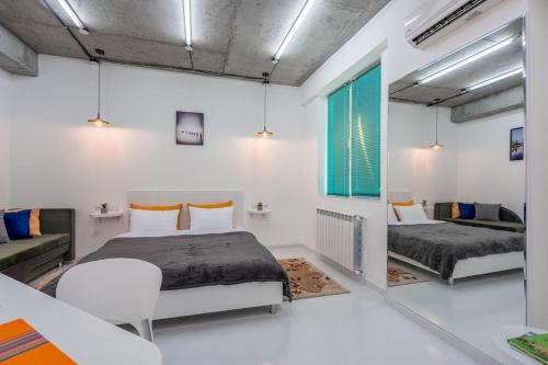 a bedroom with two beds and a table and a couch at Tbilisi Apartment*Studio Gorgasali in Tbilisi City