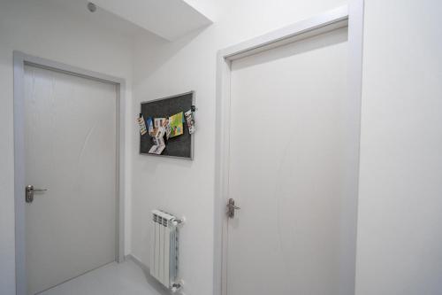 a white room with a door and a picture on the wall at Tbilisi Apartment*Studio Gorgasali in Tbilisi City