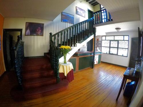 a staircase in a house with a vase of flowers on a table at Hotel La Herreria Colonial in Popayan