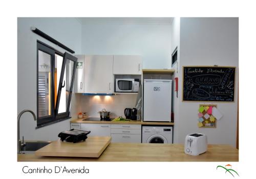 a kitchen with white cabinets and a counter top at Cantinho D'Avenida in Velas