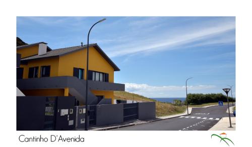 a yellow building on the side of a road at Cantinho D'Avenida in Velas