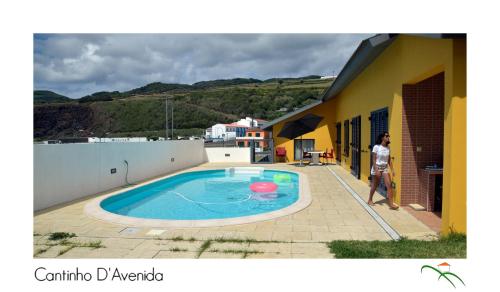 a person standing next to a small swimming pool at Cantinho D'Avenida in Velas