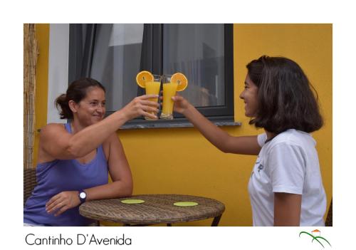a woman is holding up a trophy next to a girl at Cantinho D'Avenida in Velas