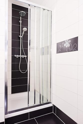 a shower in a bathroom with black and white tiles at Apartments Adriapag in Pag