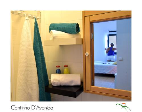 a bathroom with a mirror and a bed at Cantinho D'Avenida in Velas