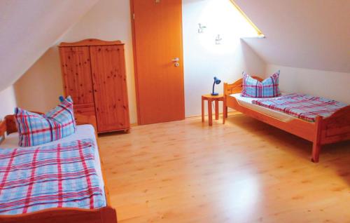 グラール・ミューリッツにあるFerienwohnung Möweのベッド2台が備わるウッドフロアの客室です。